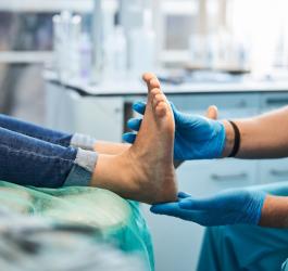 Lekarz bada stopy pacjenta.