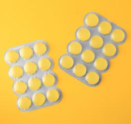 Blistry zawierające żółte pastylki do ssania.