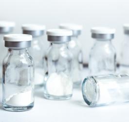 Szklane fiolki wypełnione lekiem w postaci białego proszku.