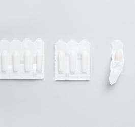 Czopki w blistrze i rozpakowane na neutralnym tle.