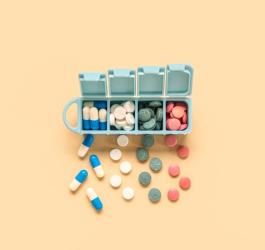 Kolorowe tabletki i kapsułki w kasetce na leki.