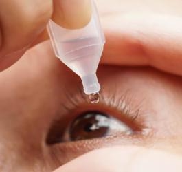 Osoba stosuje krople nawilżające na zespół suchego oka.