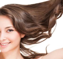 Kobieta unosi w ręce swoje piękne, zdrowe włosy.