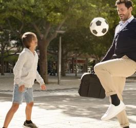 Mężczyzna gra z chłopcem w piłkę.